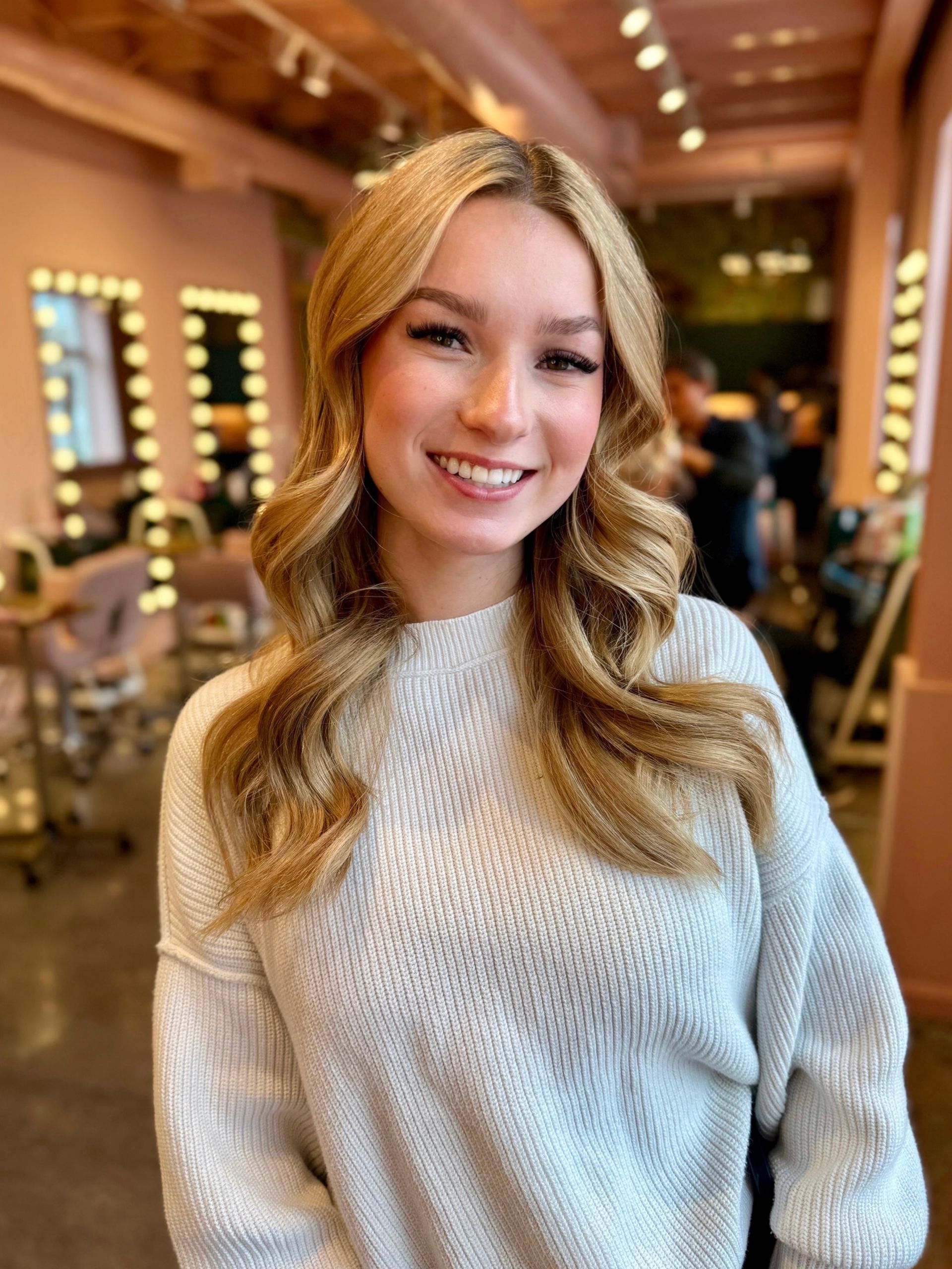 Peach-colored wall casting shadow on sand, palm tree fronds against a turquoise sky.