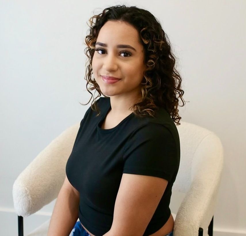 A woman in a black shirt is sitting in a chair