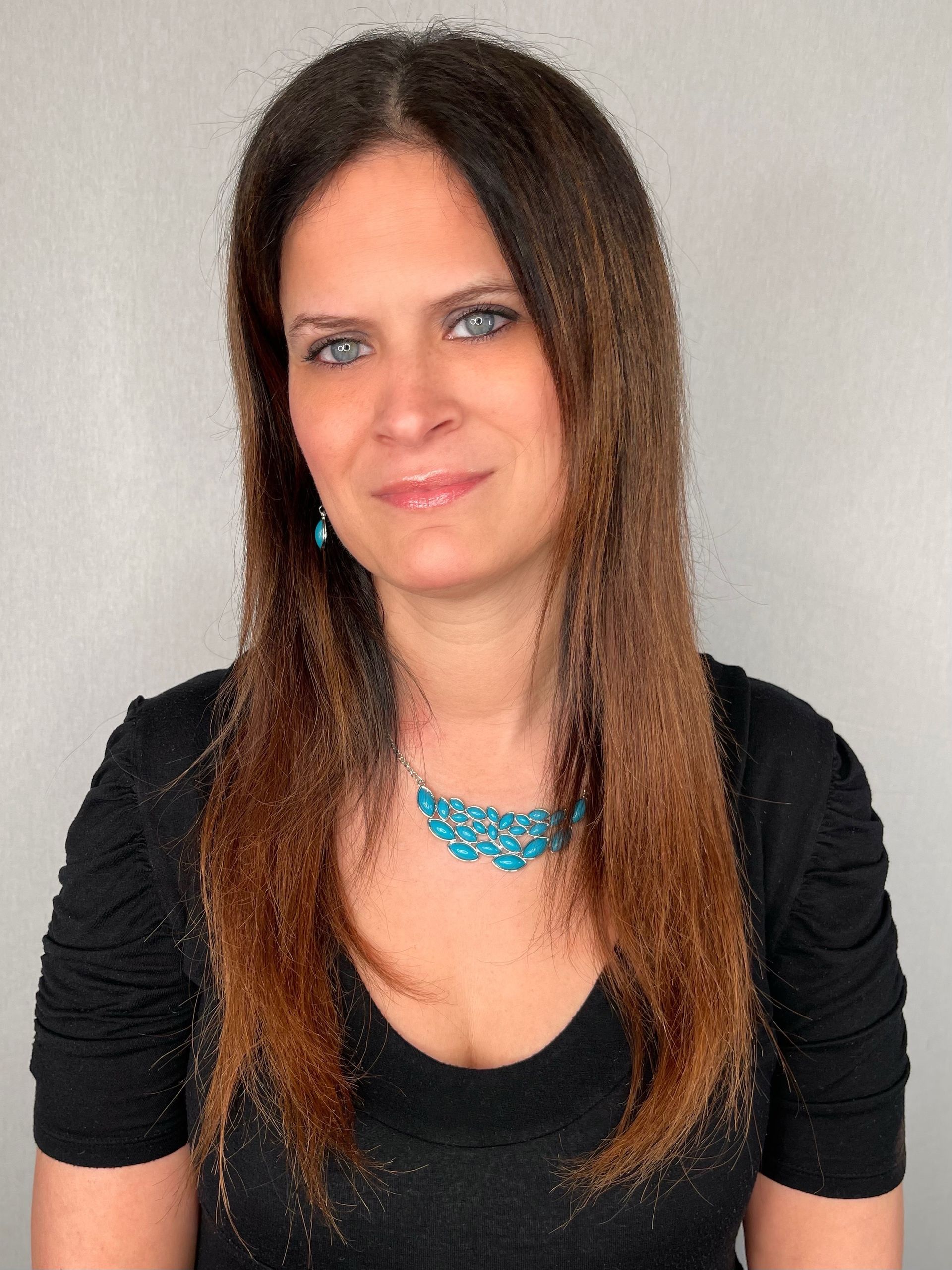 A woman wearing a black shirt and a blue necklace