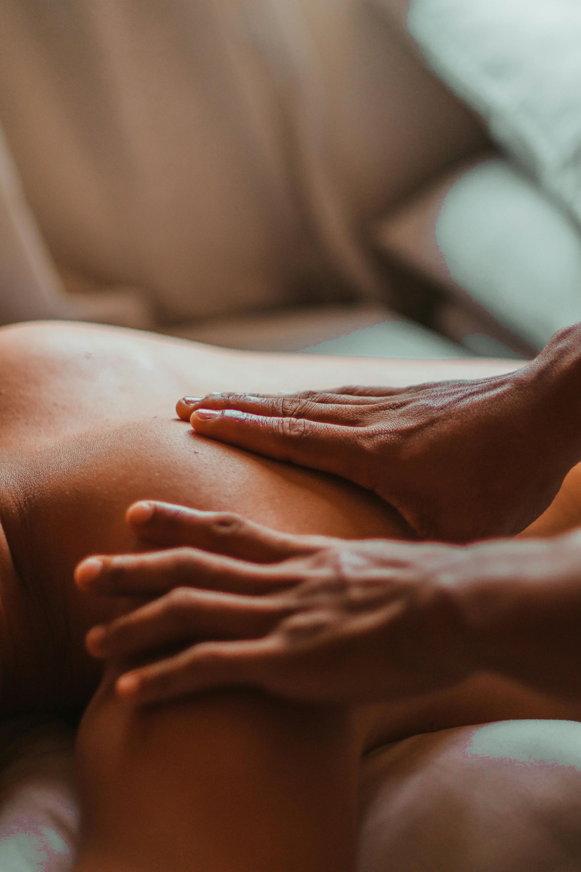 Hands giving a back massage on a person lying down