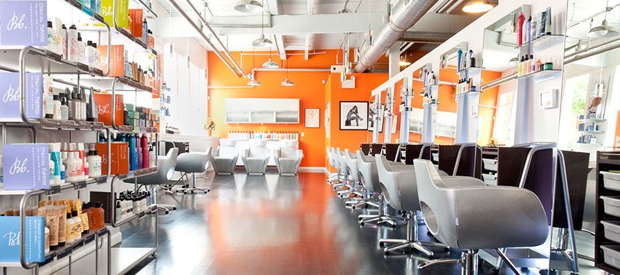 A hair salon with a lot of chairs and shelves.