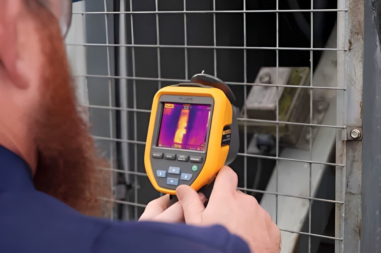 A Man is Holding a Thermal Camera — Dowds Pipe and Cable Locating in Farmborough Heights, NSW