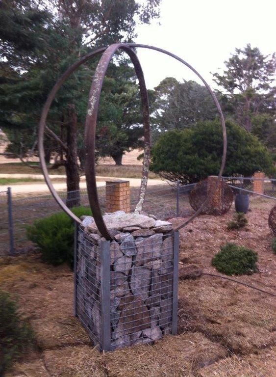 A large metal ring is sitting on top of a pile of rocks
