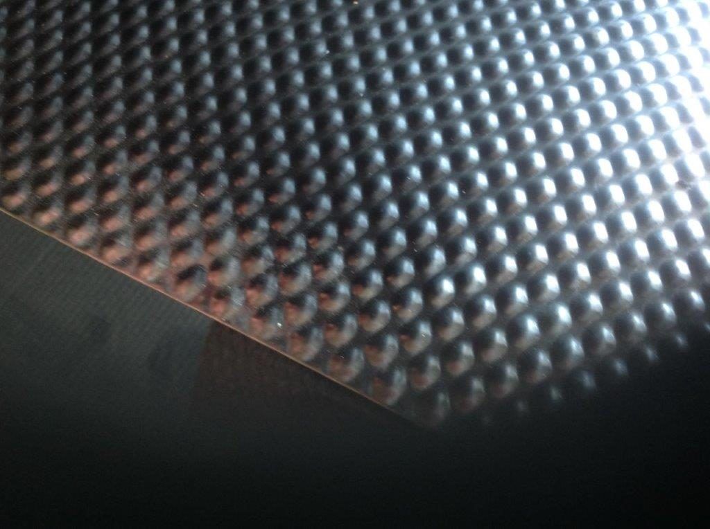 A close up of a metal surface with holes in it
