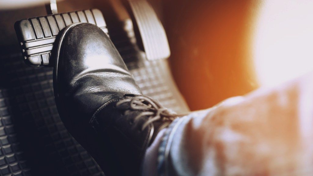 A person is pressing the brake pedal of a car. | Karta Motorwerks