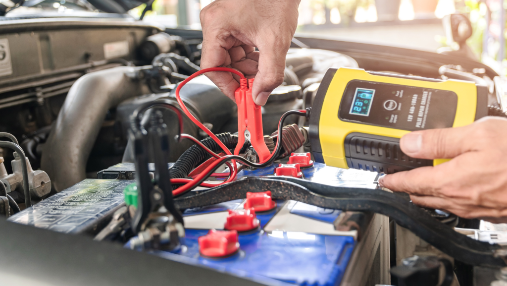 A person is charging a car battery with a charger | Karta Motorwerks