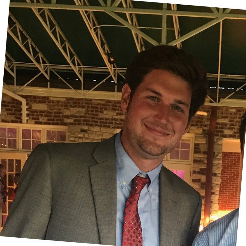 A man in a suit and tie smiles for the camera