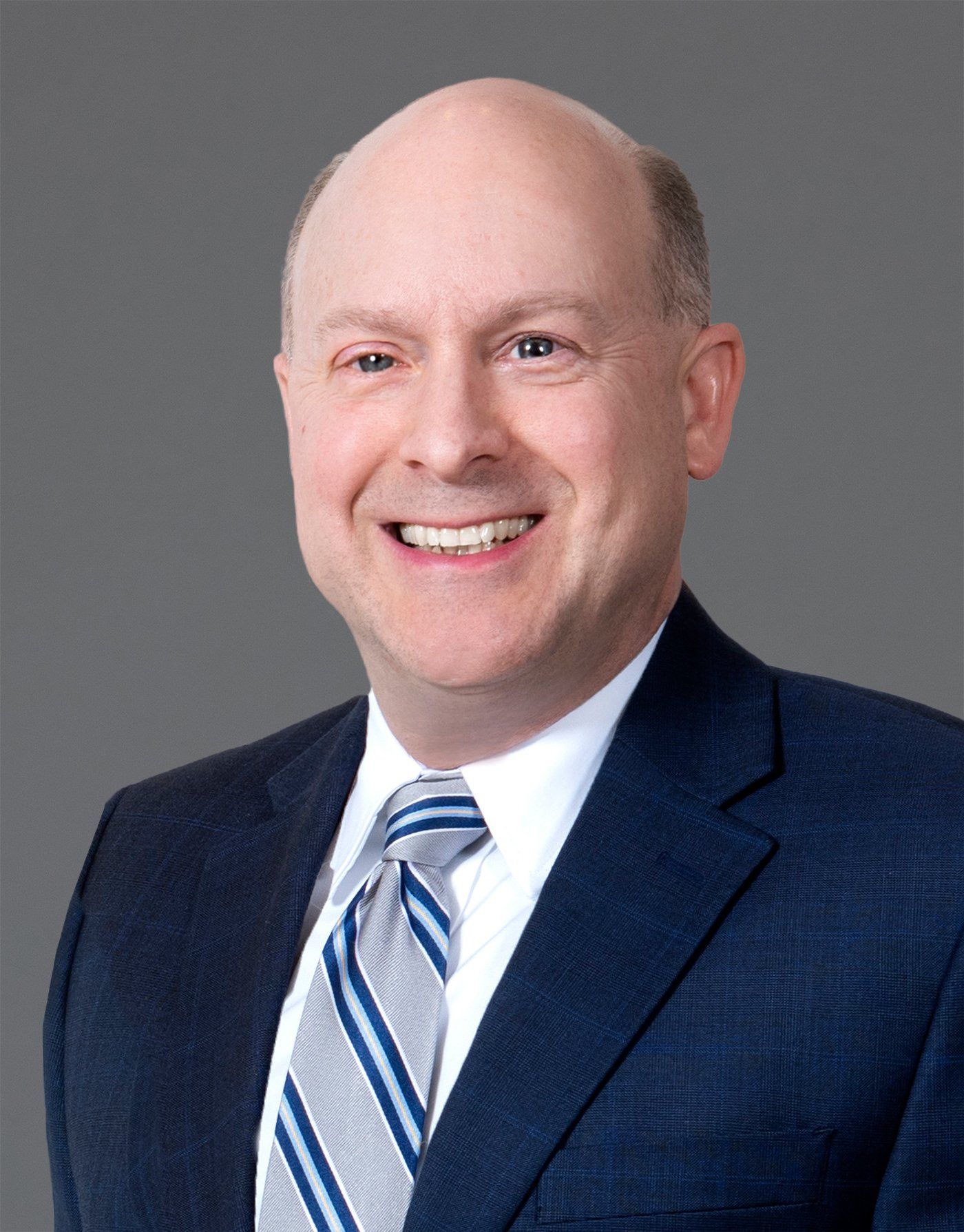 A man in a suit and tie is smiling for the camera.