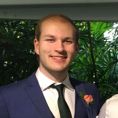 A man in a suit and tie is smiling for the camera