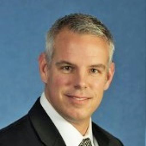 A man in a suit and tie is smiling for the camera.