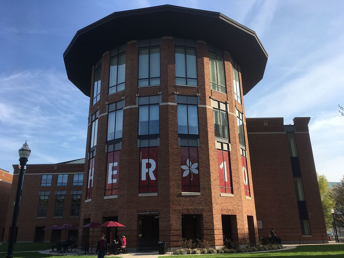 A large brick building with a sign that says ' here ' on it