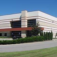 A large white building with a car parked in front of it.