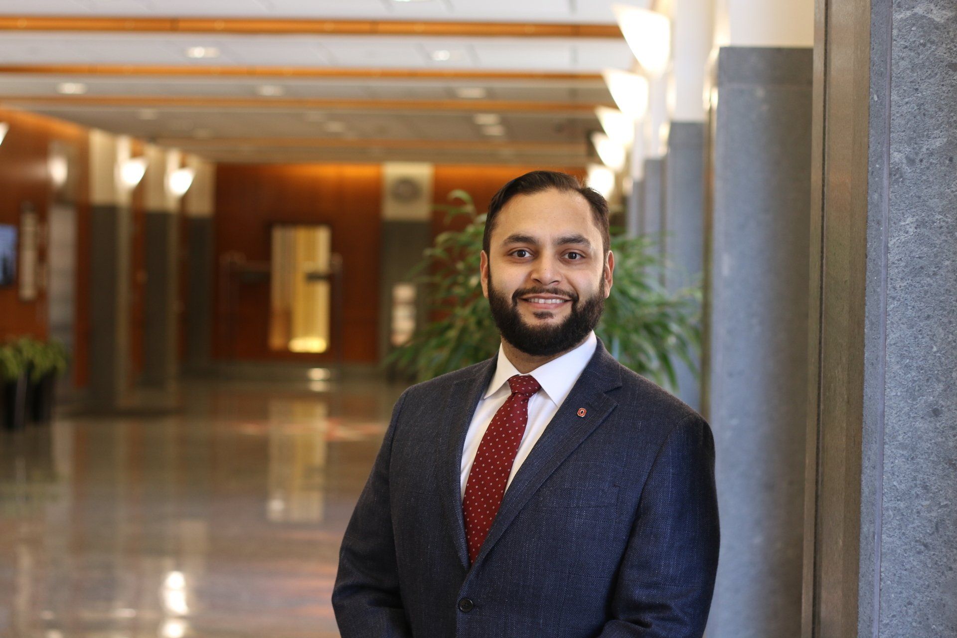 A man in a suit and tie is standing in a hallway.