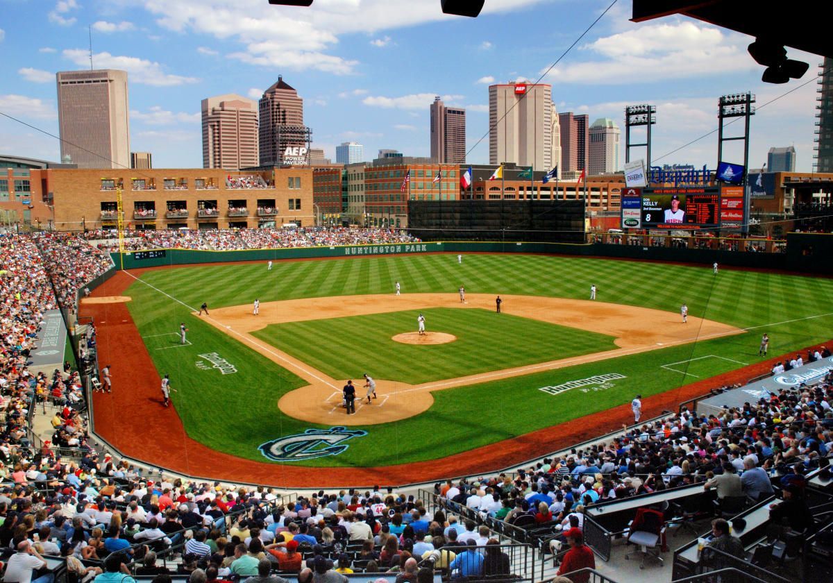 A baseball field with a city in the background