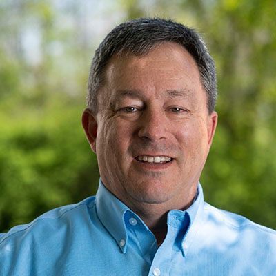 A man in a blue shirt is smiling for the camera.