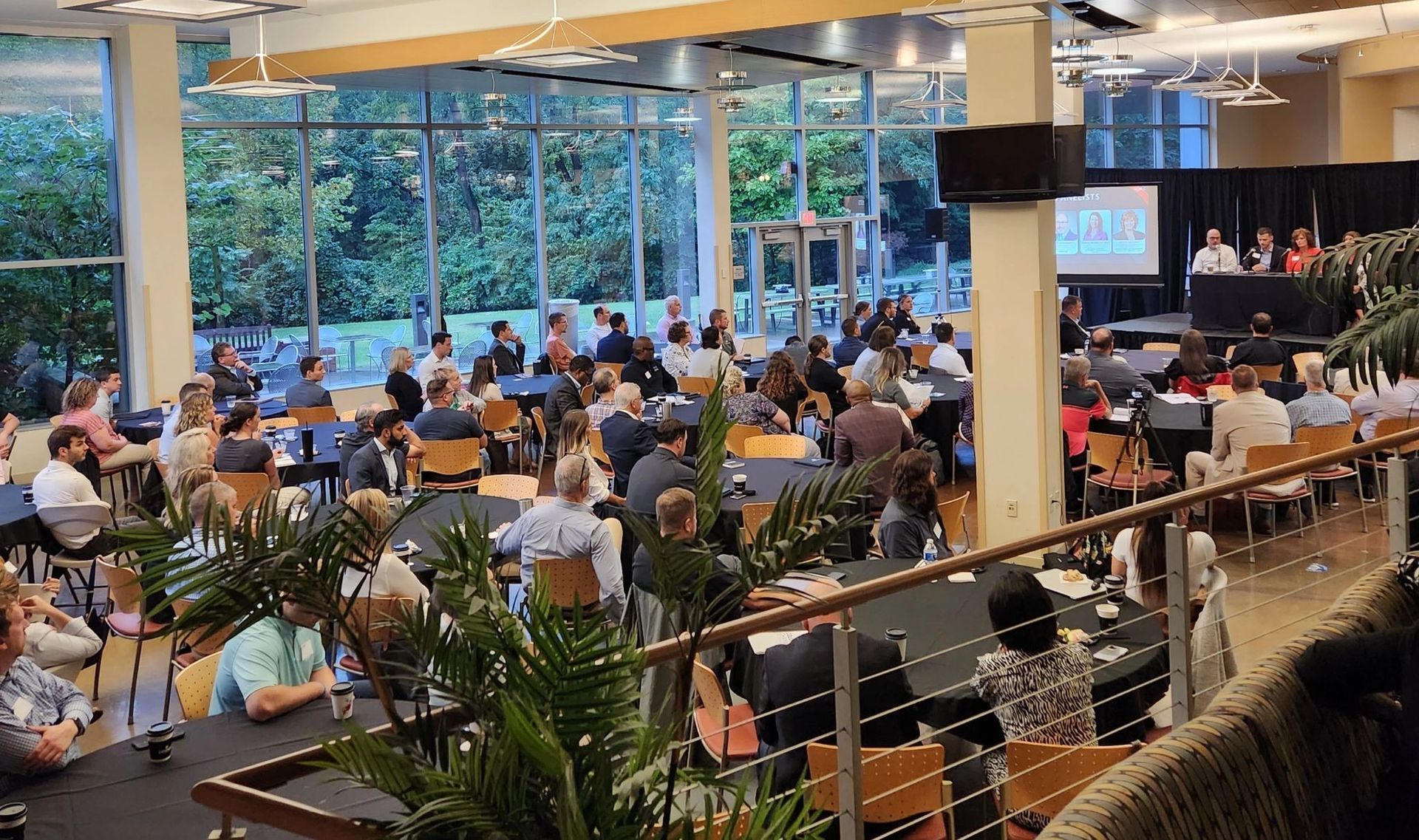 A large group of people are sitting at tables in a large room.