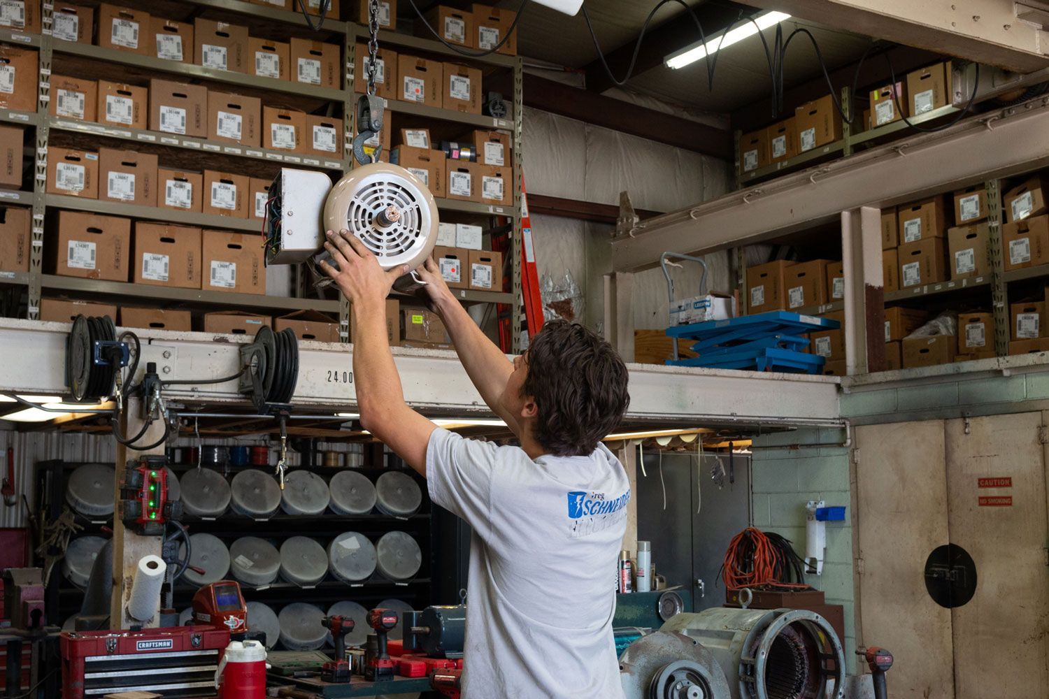 A man is working on a machine in a warehouse.