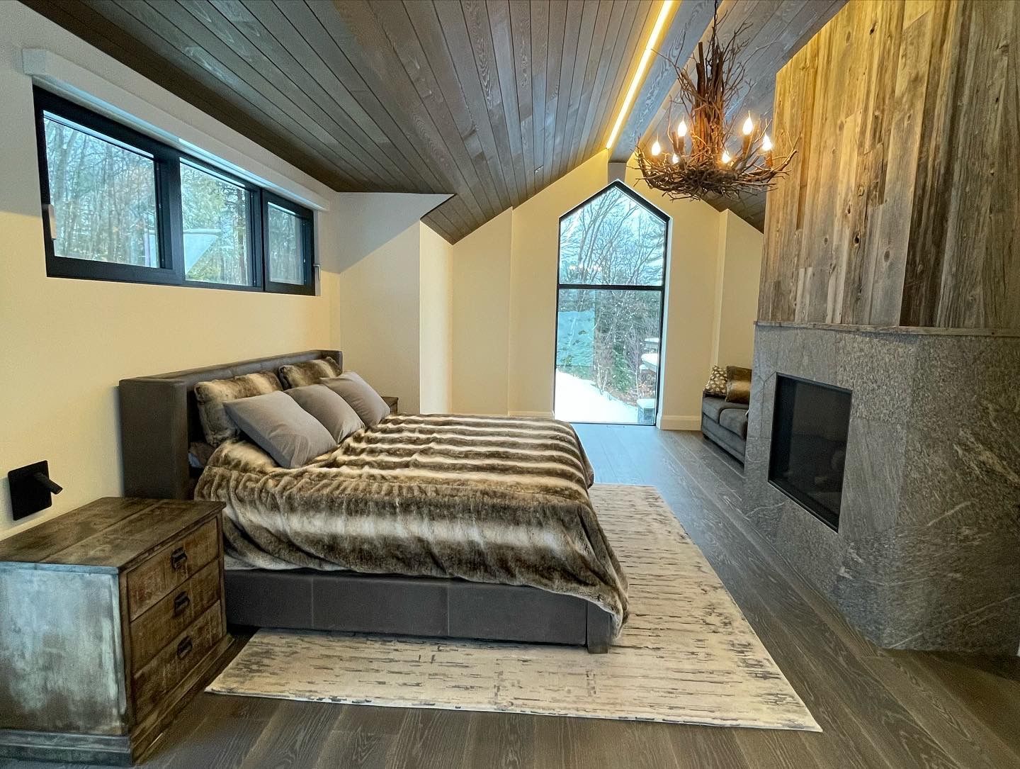 A large bedroom with a fireplace and a large bed.
