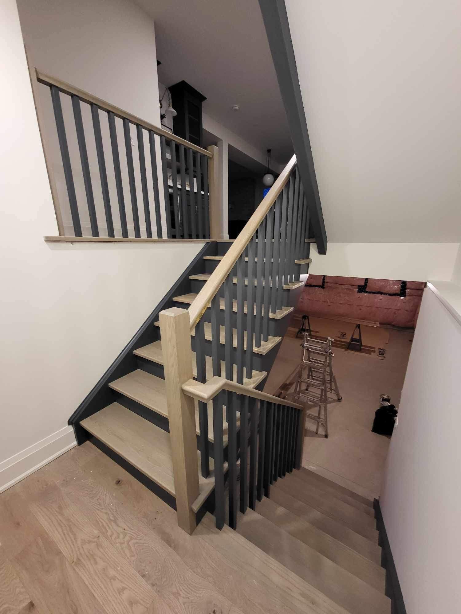 A staircase with a wooden railing leading up to a living room.