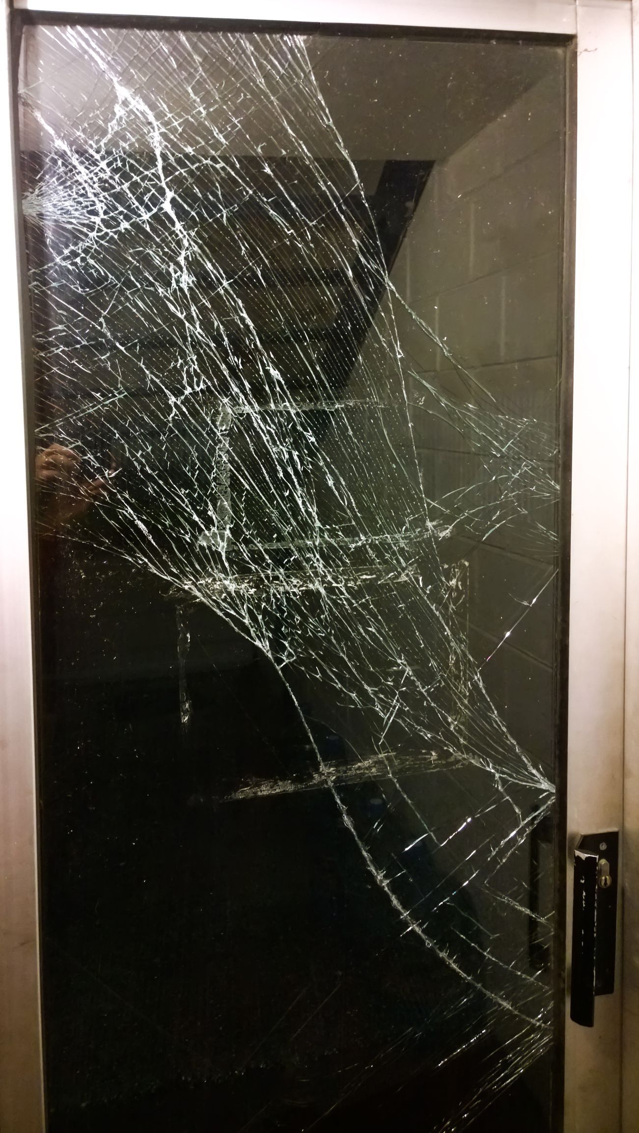 The glass door panel was smashed, requiring urgent professional repair.