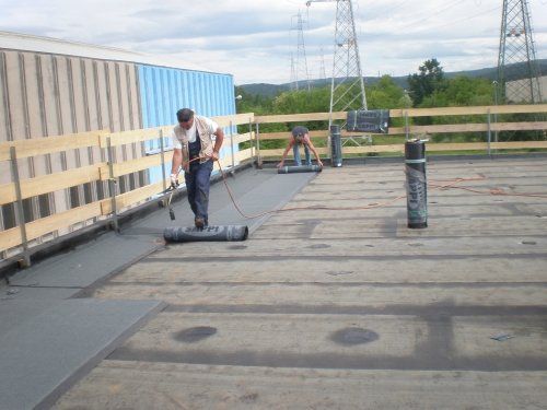 operai durante la posa di un isolante per tetti