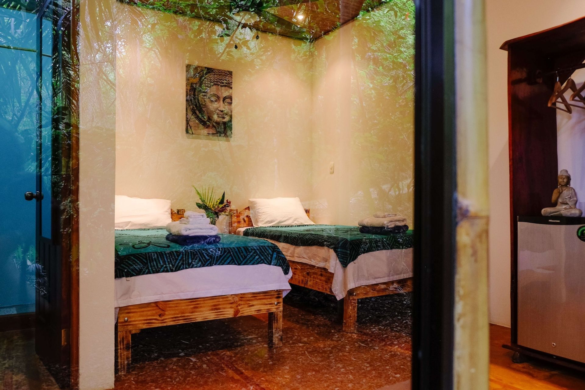 A bedroom in Costa Rica with two beds and a painting on the wall.