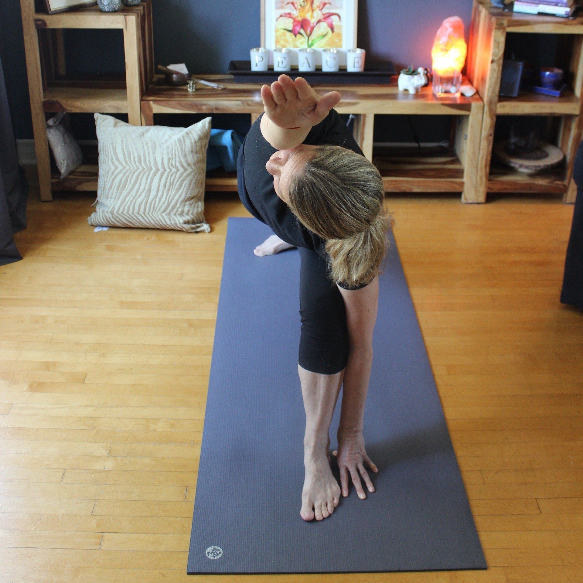 A woman is doing a yoga pose on a mat