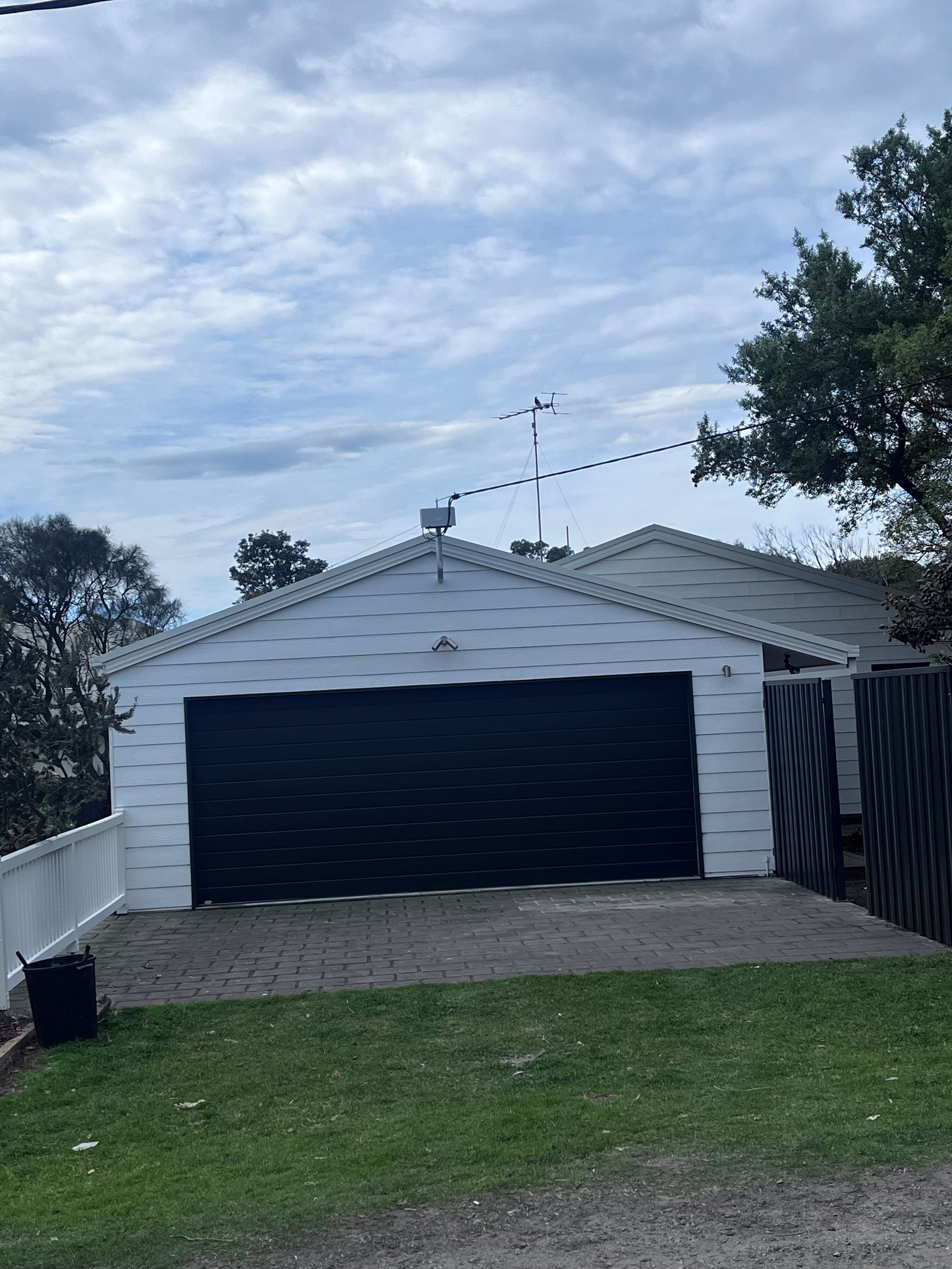 A white house with a black garage door