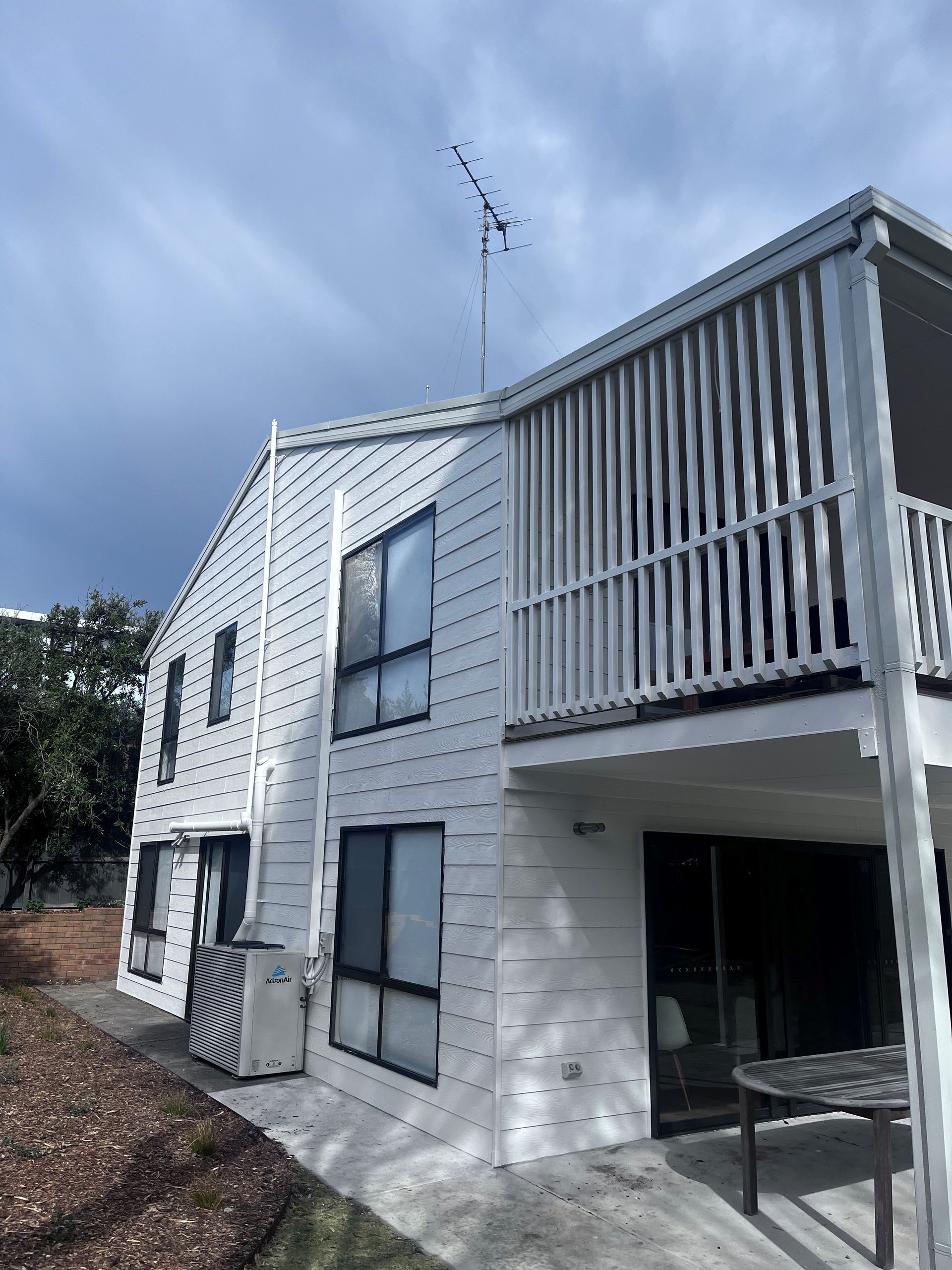 A large white house with a balcony on the second floor.