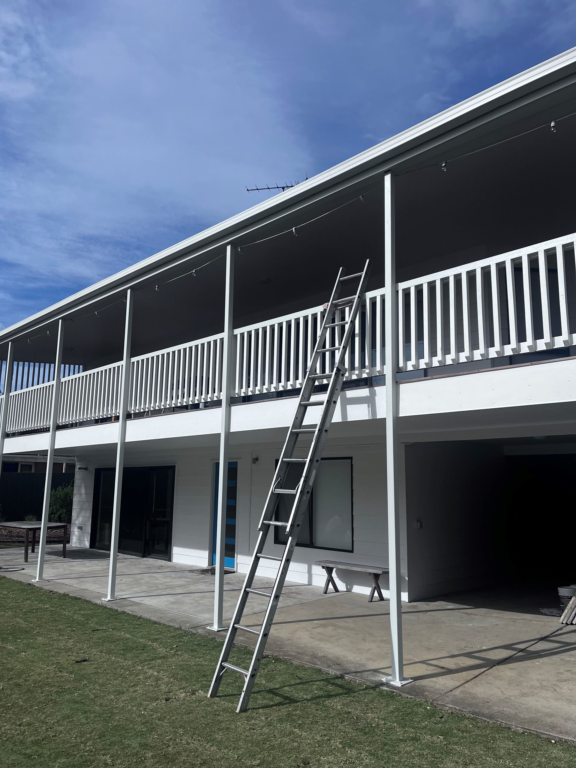 A large white building with a ladder on the side of it.