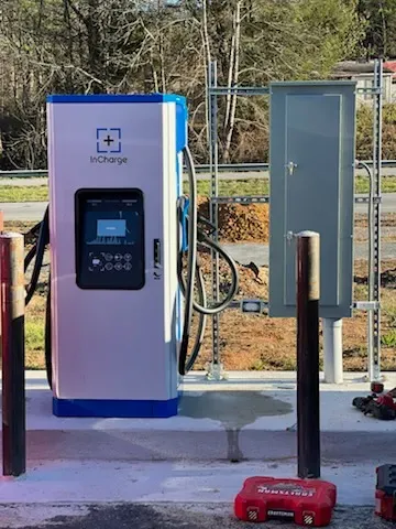 Electric vehicle charging station with blue and white accents, in outdoor setting.
