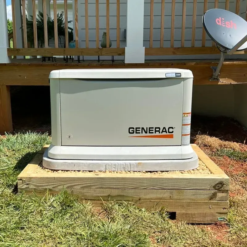 A Generac generator on a wooden platform beside a house deck, satellite dish visible.