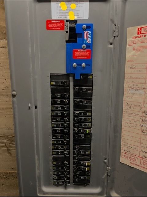 Electrical panel with circuit breakers and a blue safety device.