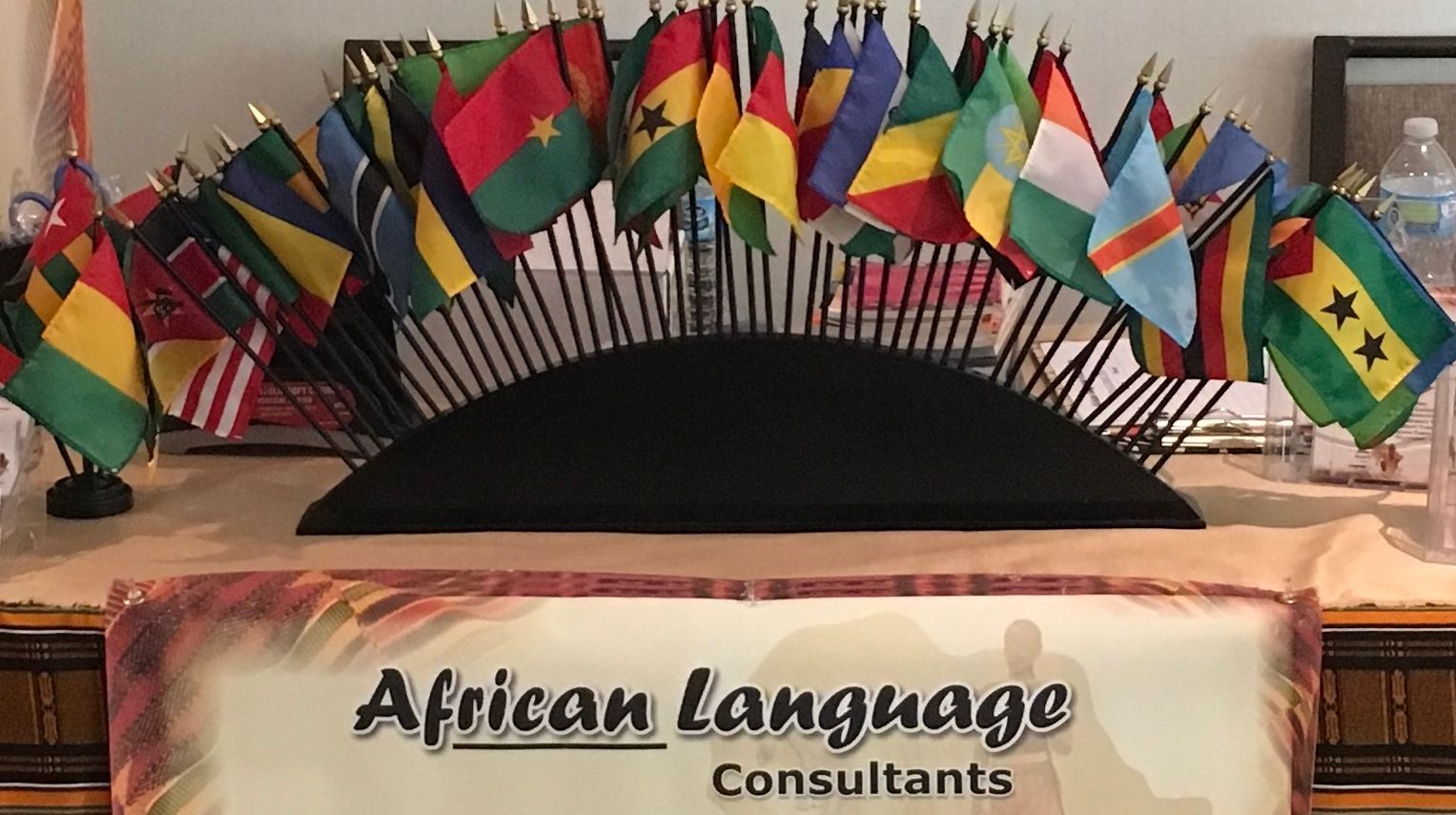 A table with a bunch of flags on it and a sign that says african language consultants.