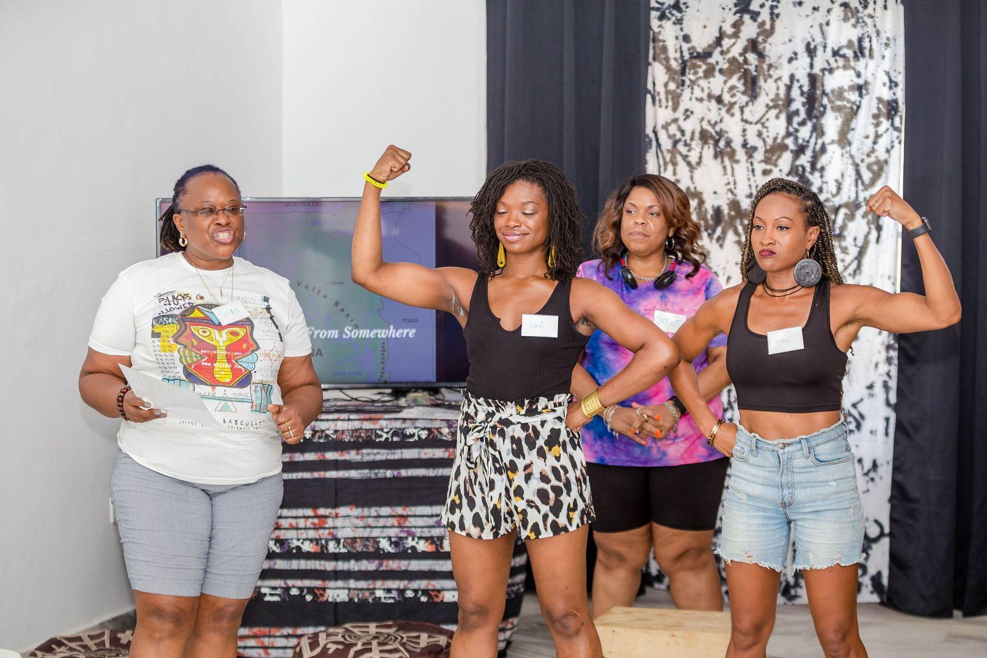 A group of women are standing next to each other in a living room.