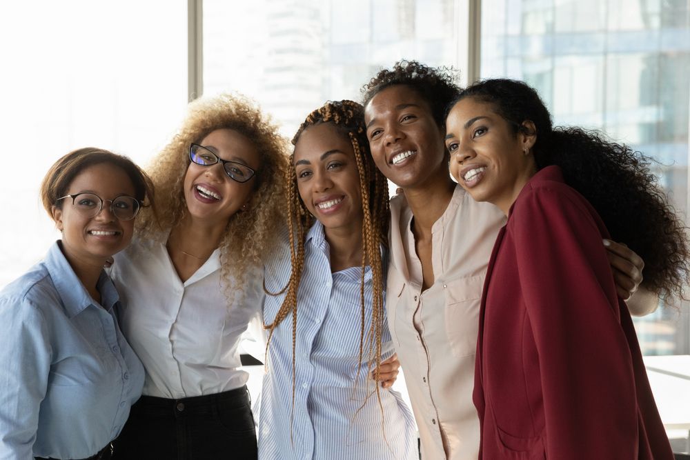 A group of women are posing for a picture together and smiling.