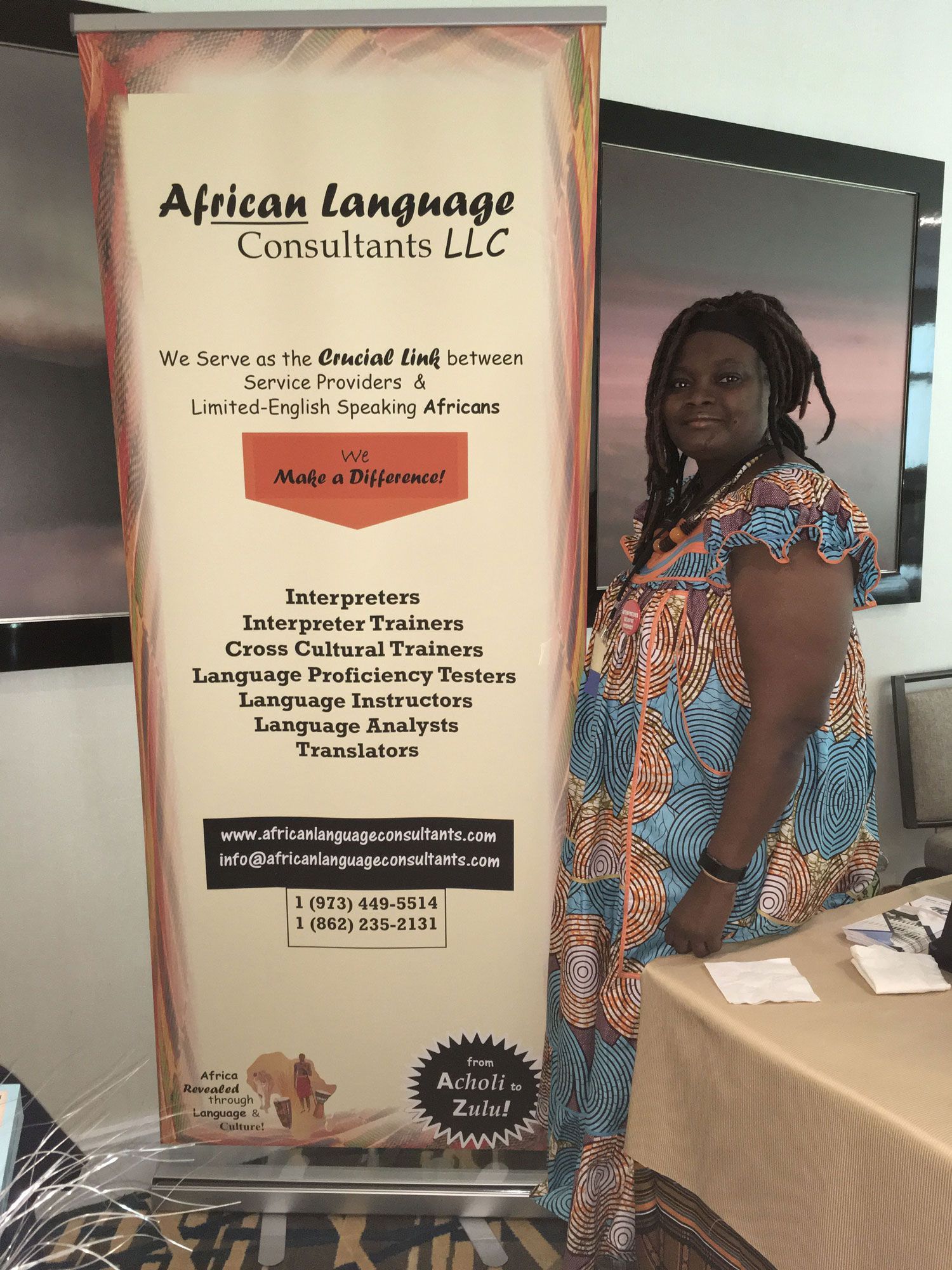 A woman is standing in front of a sign that says african language consultants llc.
