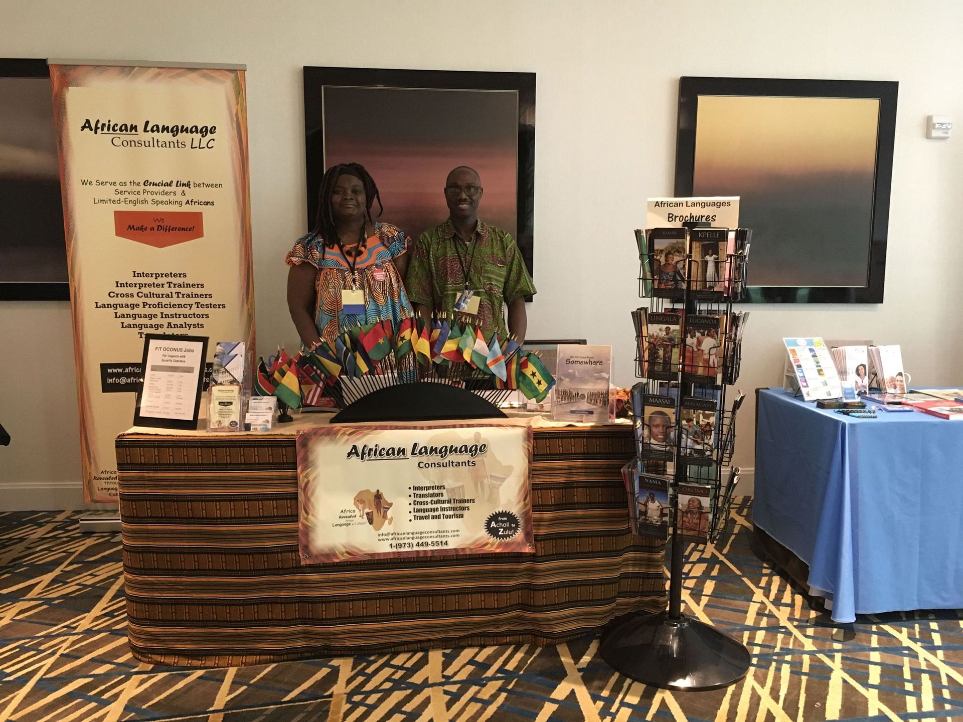 A man and a woman are standing behind a wooden desk.