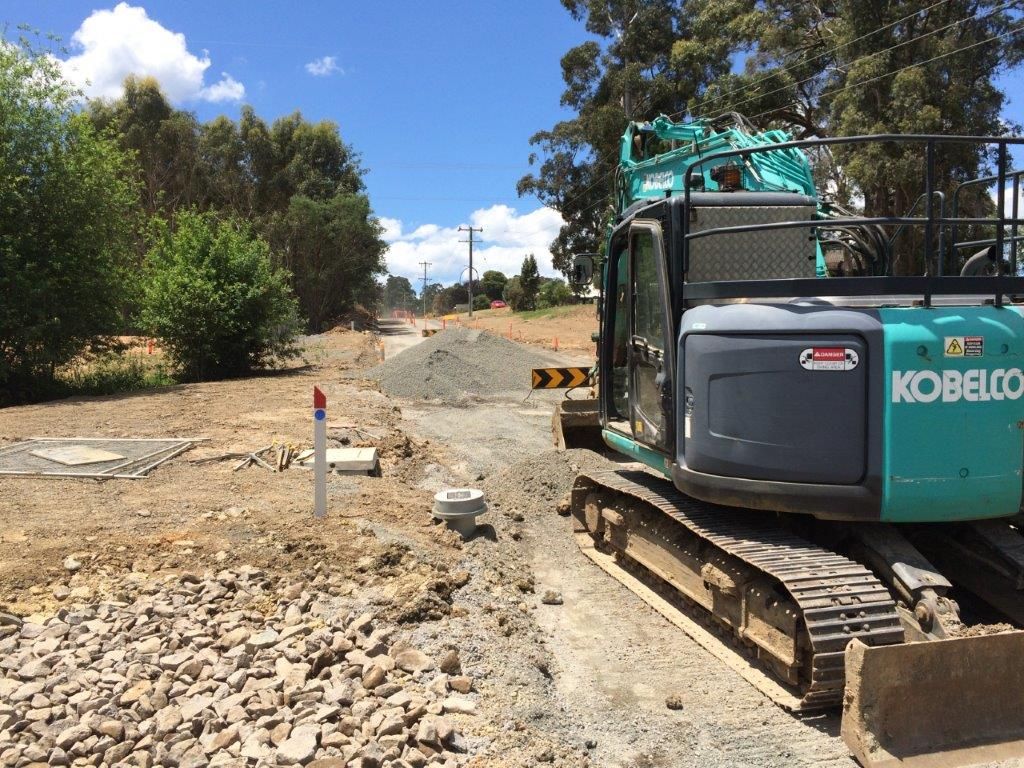 Backhoe Excavating Old Road — Ballarat VIC — Ballarat Excavation & Transport