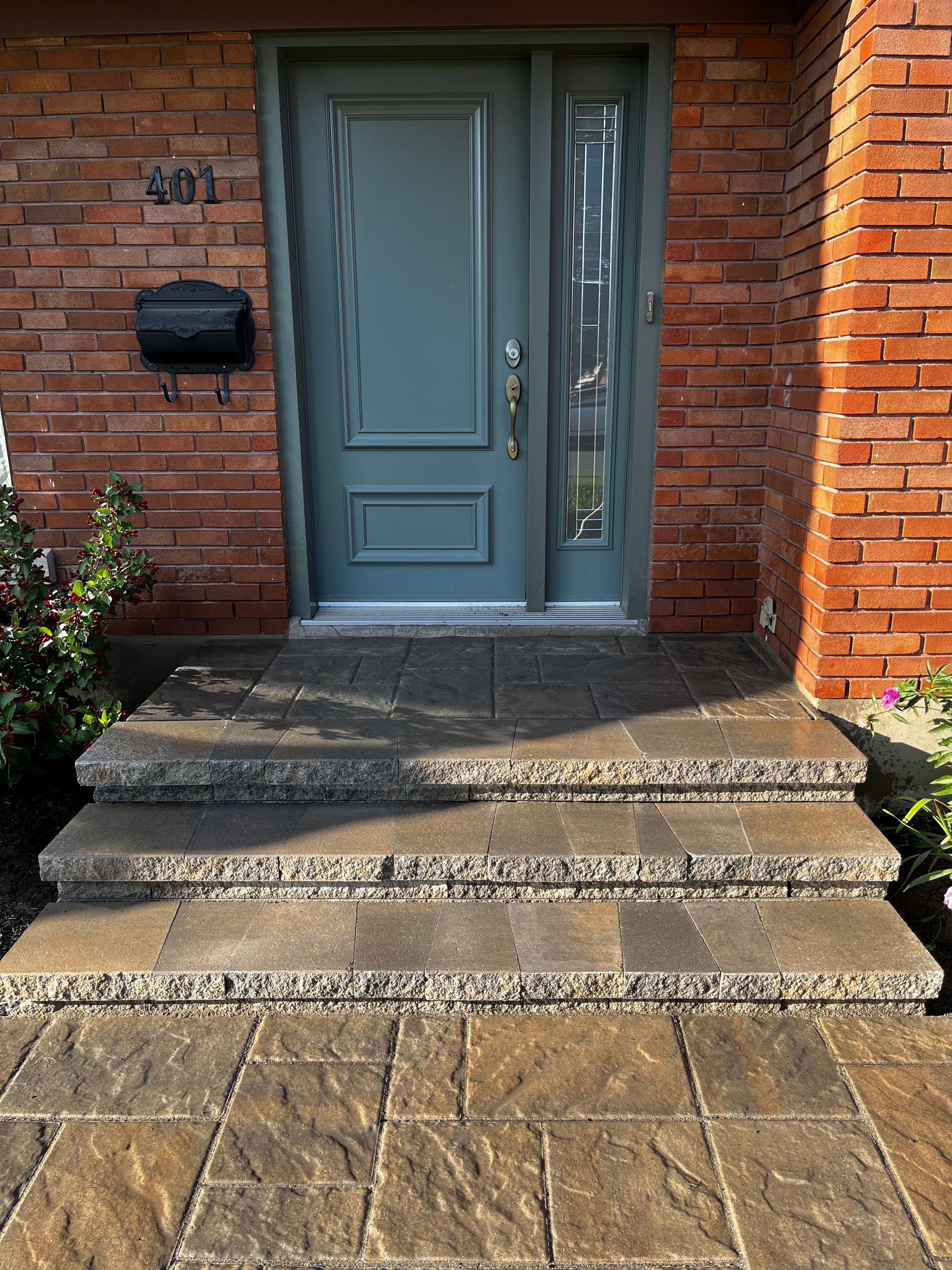 La porte d'entrée d'une maison en brique avec une porte et des marches bleues.