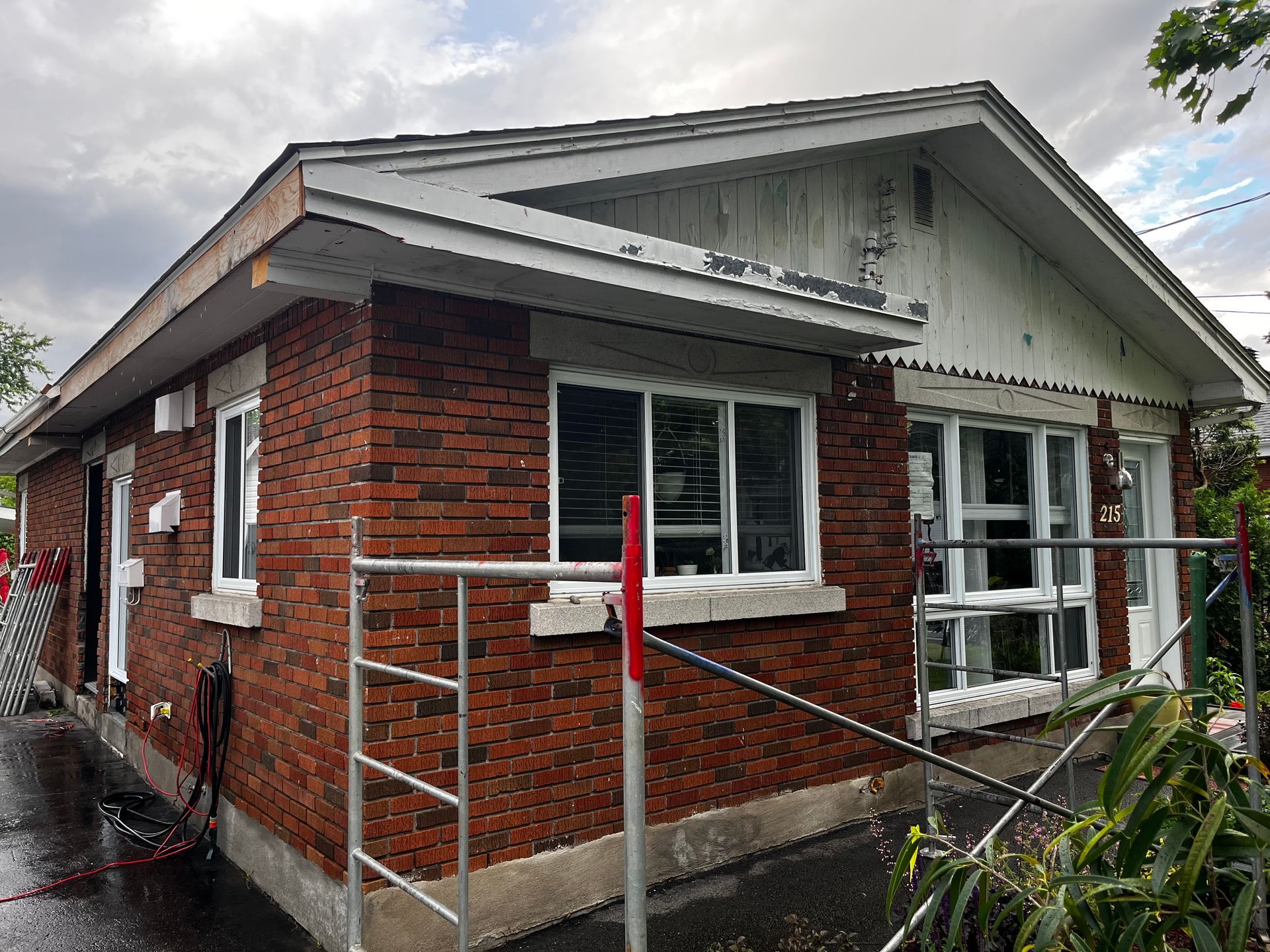 Une maison en brique avec un toit blanc est en cours de rénovation.