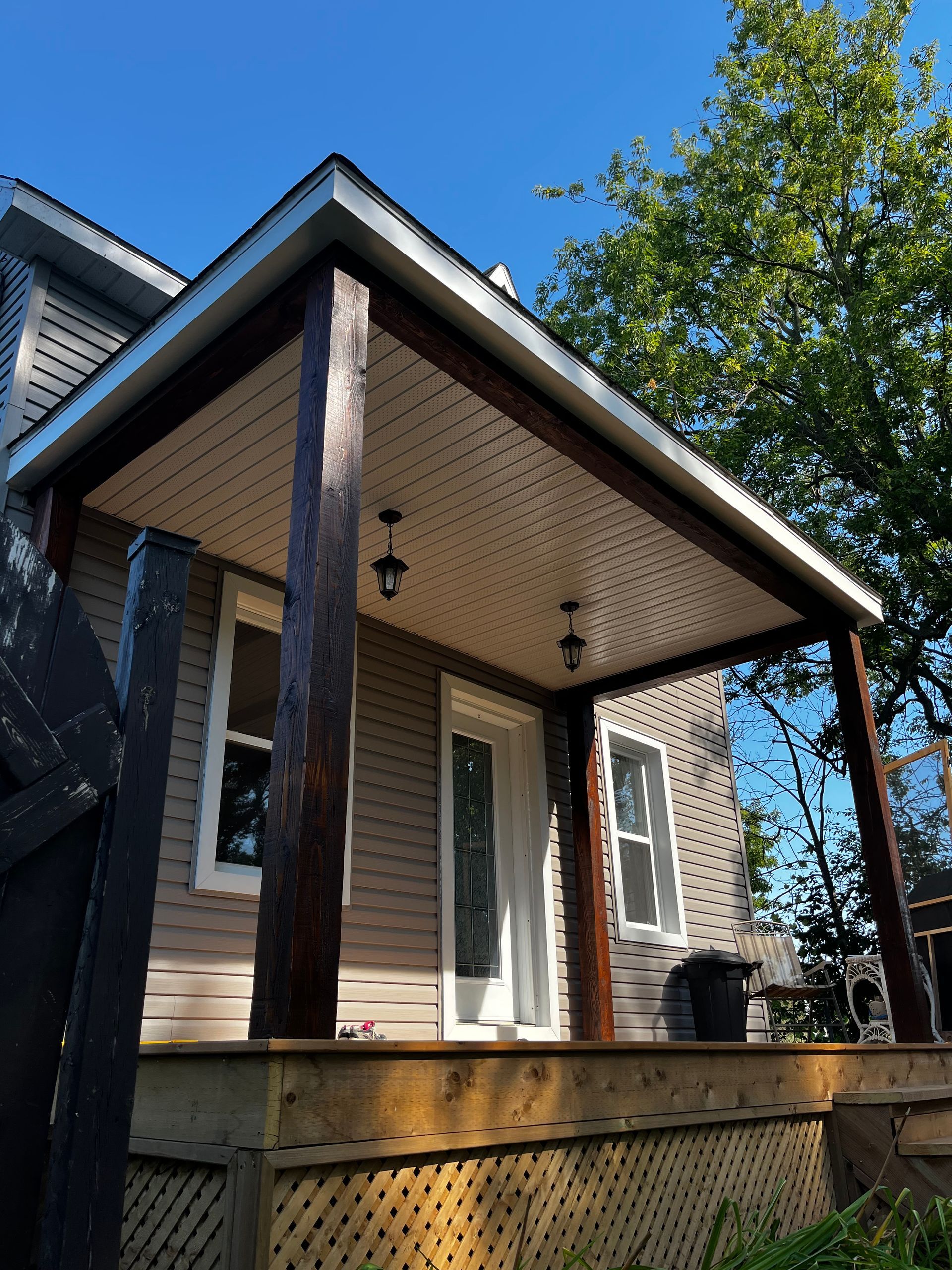 Une maison avec un porche et un arbre en arrière-plan