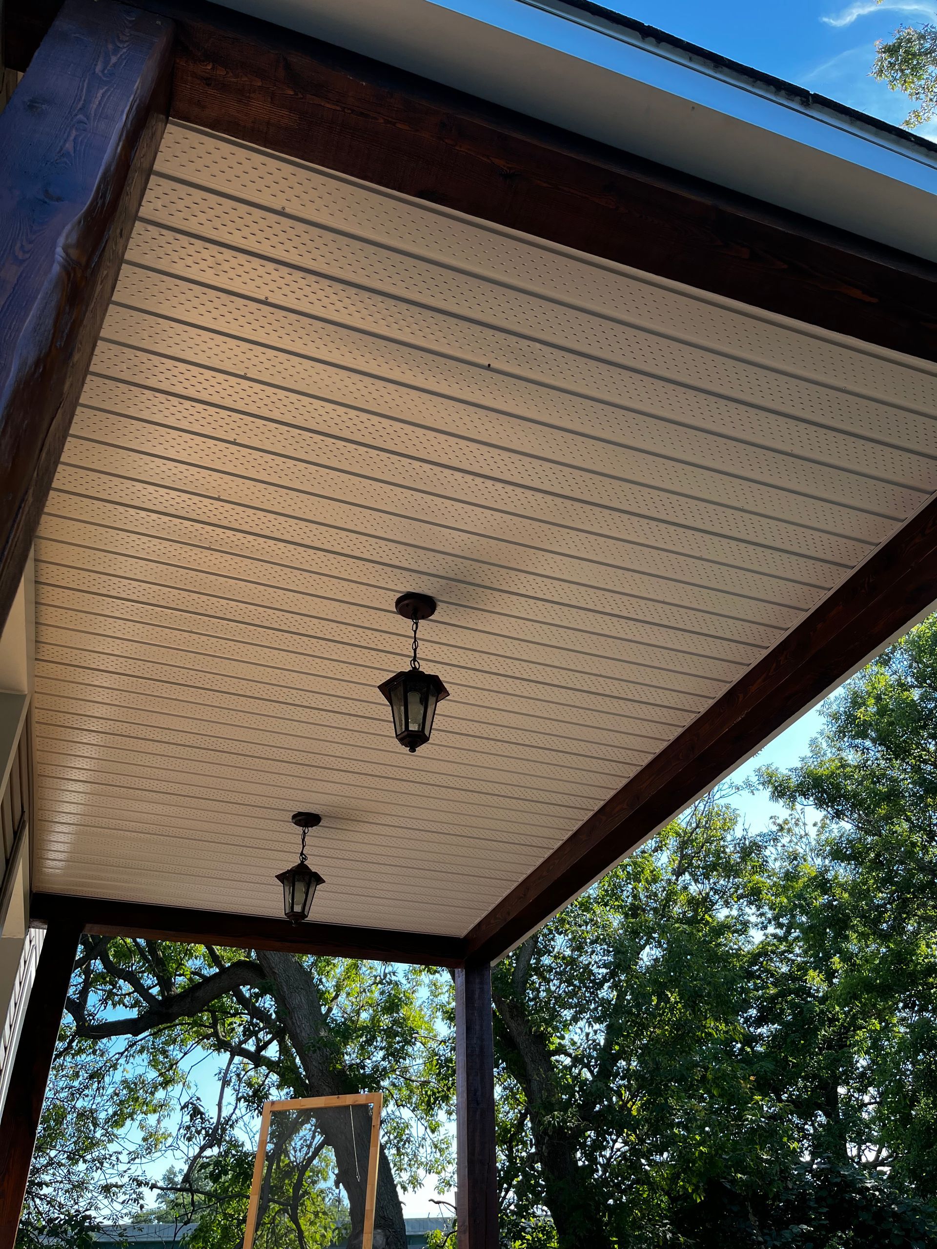 Le plafond d'un porche avec deux lanternes suspendues