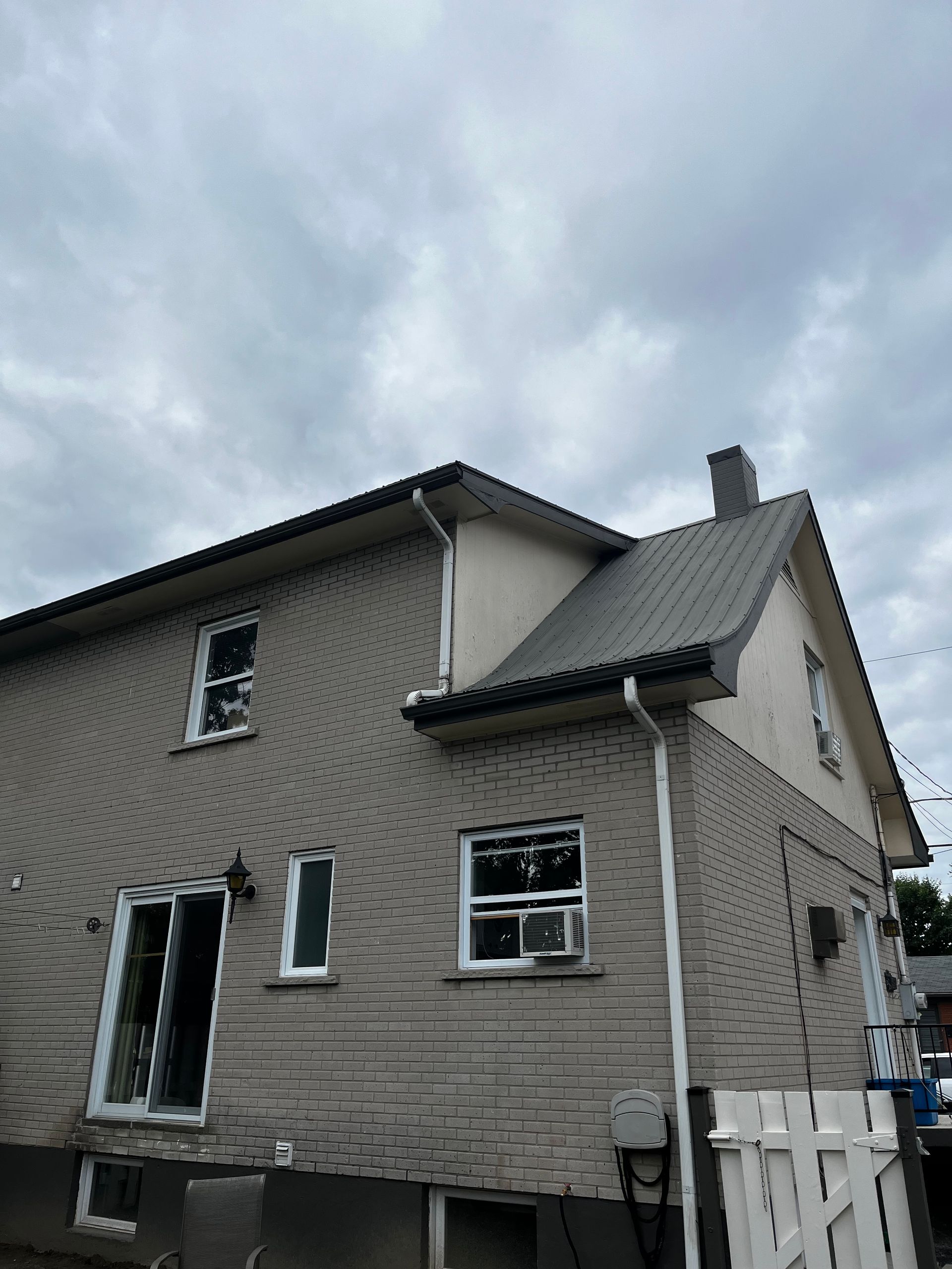 Une maison avec un toit sur lequel se trouve une cheminée