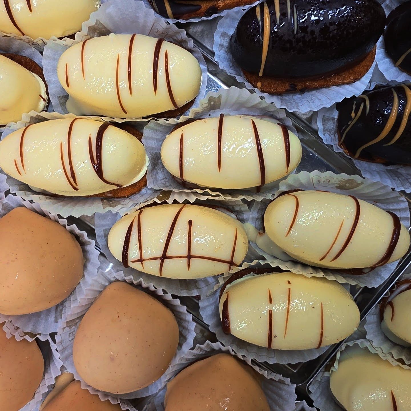 Pasticcini con glassa bianca e scura, disposti in pirottini di carta.
