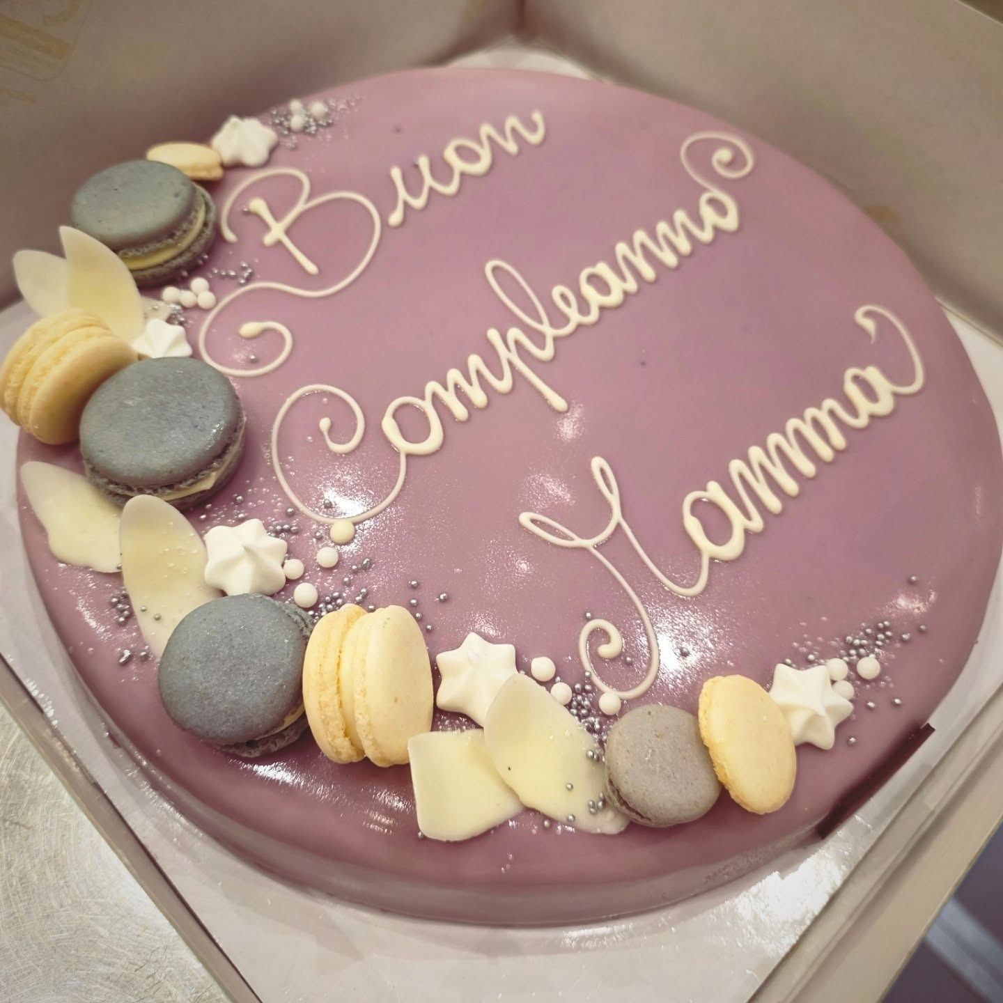 Torta glassata viola decorata con macarons e scritta 