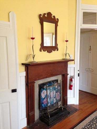 A living room with a fireplace and a mirror on the wall.