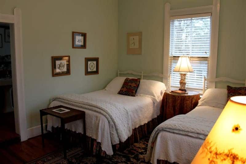 A bedroom with two beds and a lamp