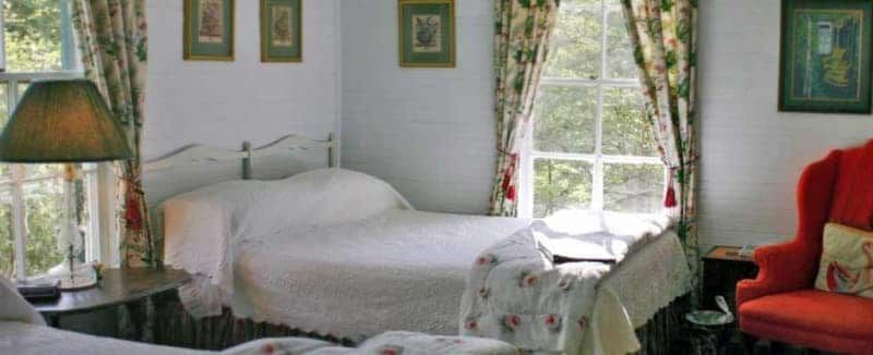 A bedroom with two beds and a red chair