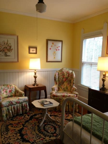 A living room with yellow walls and a bed